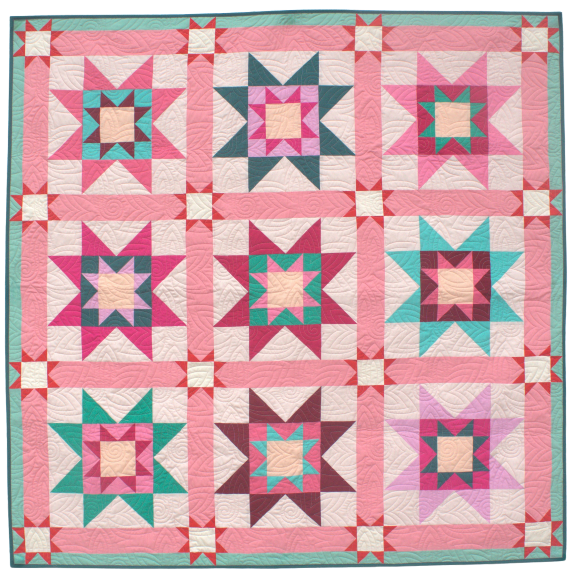 Quilt with star pattern in pink, green, and white on a blue background